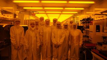 High school students in bunny suits inside the cleanroom ready to observe semiconductor fabrication process